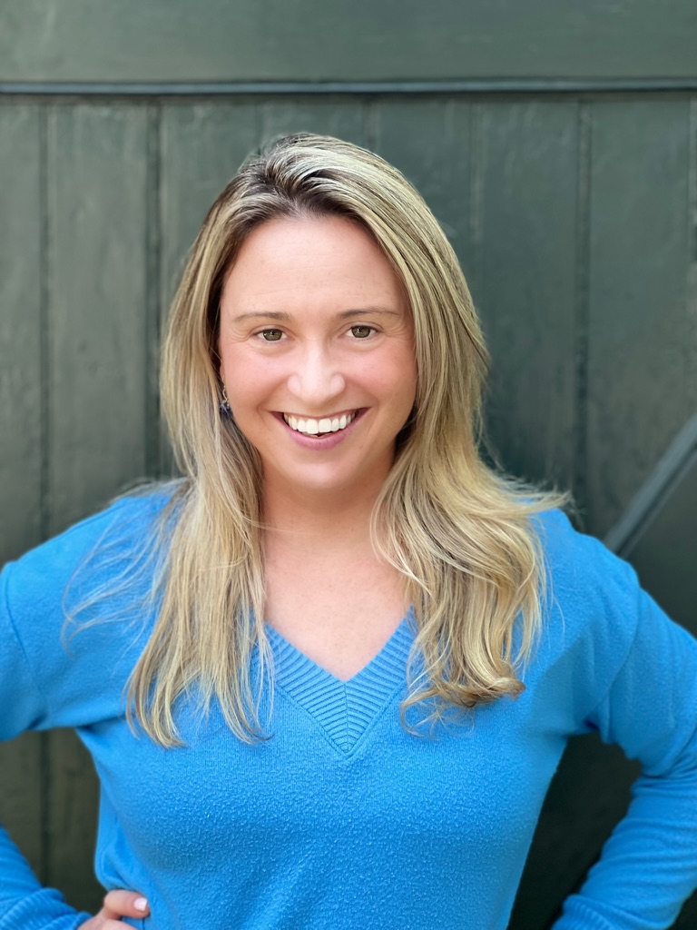 Molly Lazarus, smiling, in a blue sweater